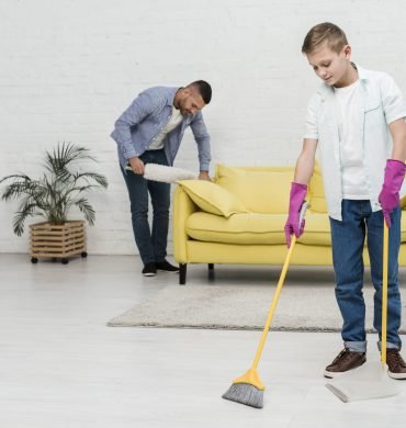 father-using-duster-while-son-uses-broom